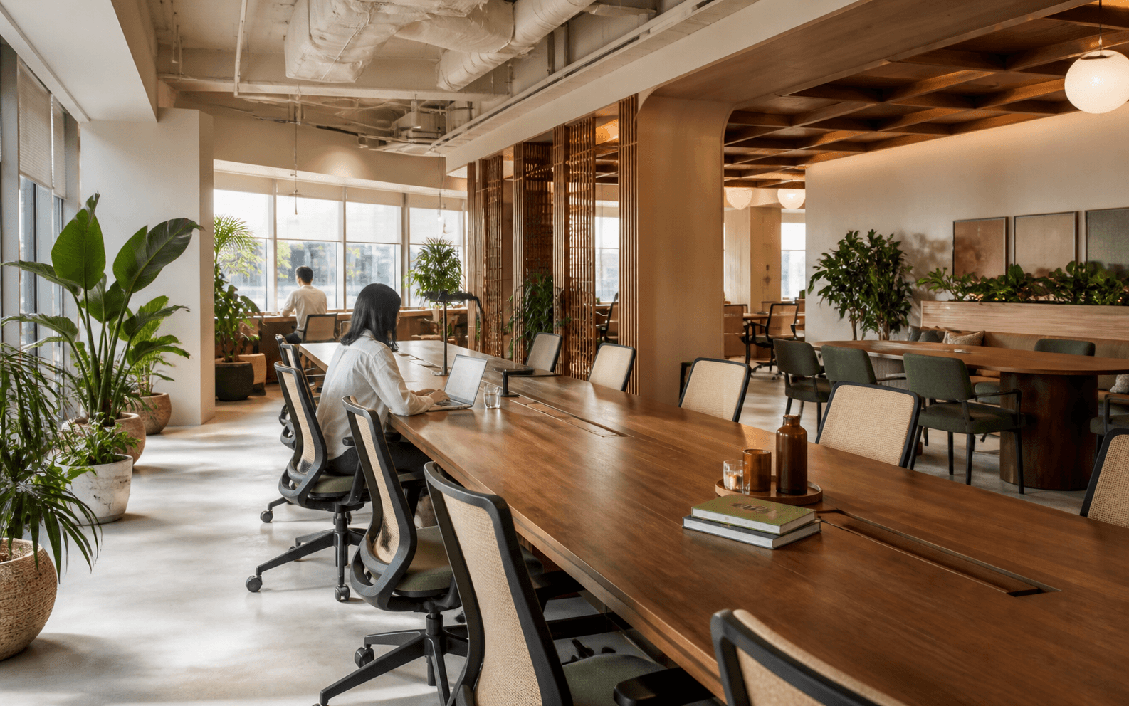 Light-filled shared hot-desk workspace with long timber tables